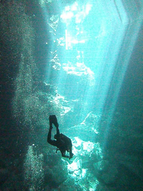 Mergulhando em meio aos raios de luz que penetram no Cenote The Pit, em Tulum, no Yucatán, sul do México